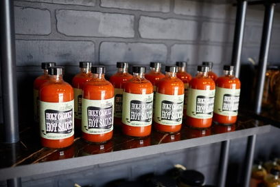Rows of Holy Caution Hot Sauce sitting on a shelf
