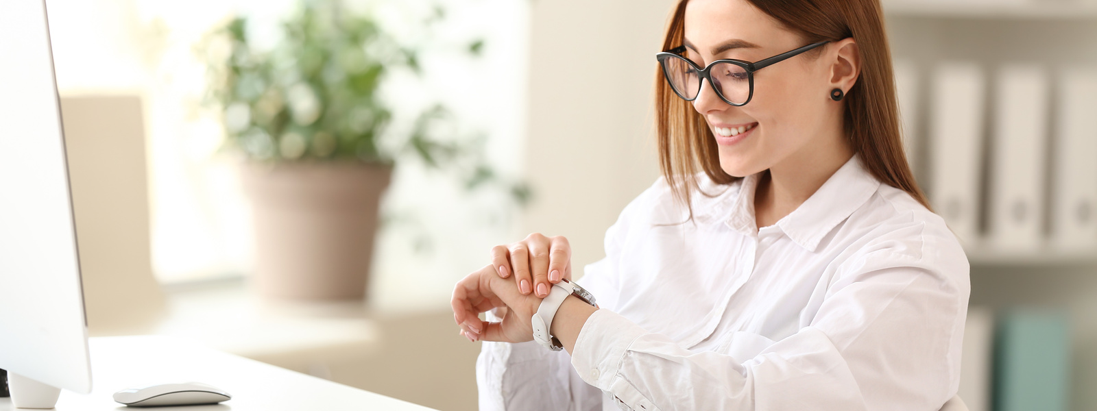 Woman looking at her watch in office
